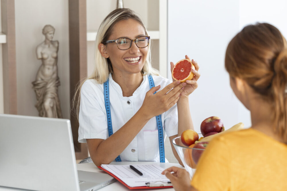 Female nutritionist giving consultation to patient. Making diet plan. Young woman visiting nutritionist in weight loss clinic